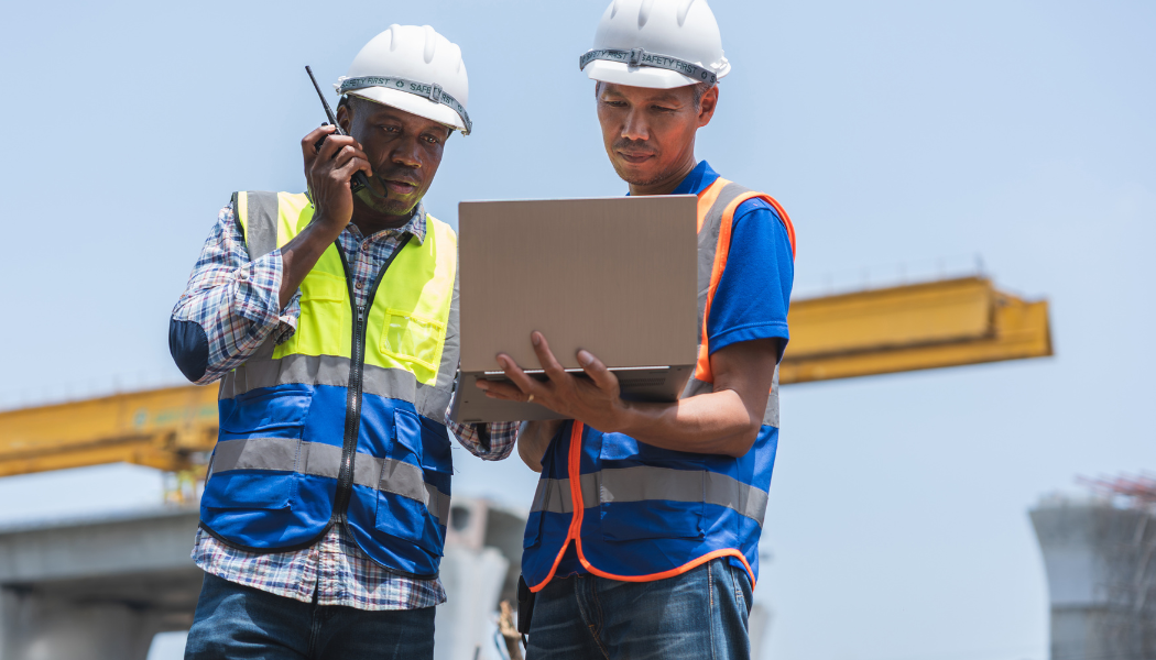 2 hommes sur un chantier qui regardent un ordinateur 